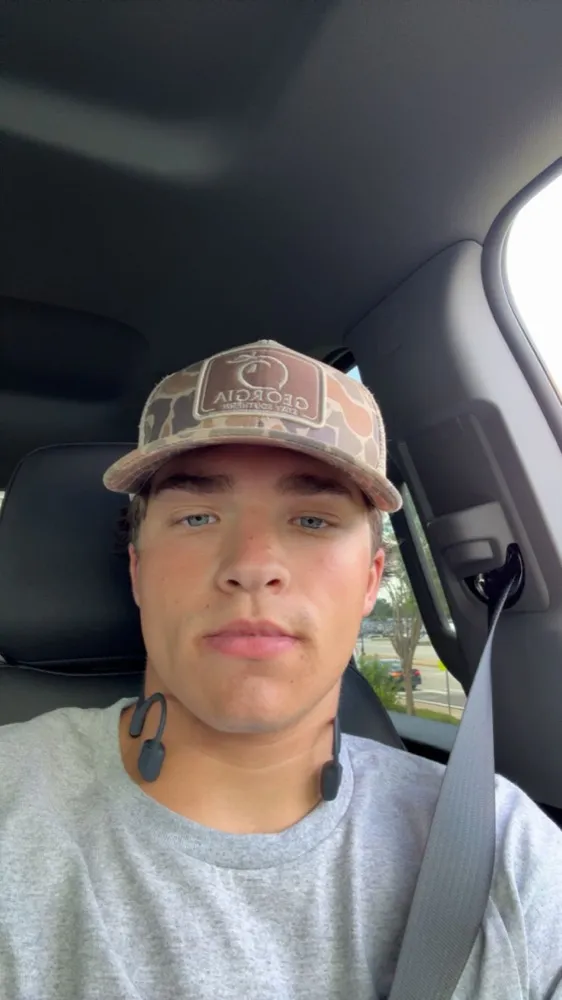 AJ Phillips in the driver's seat of his truck wearing a Georgia cap