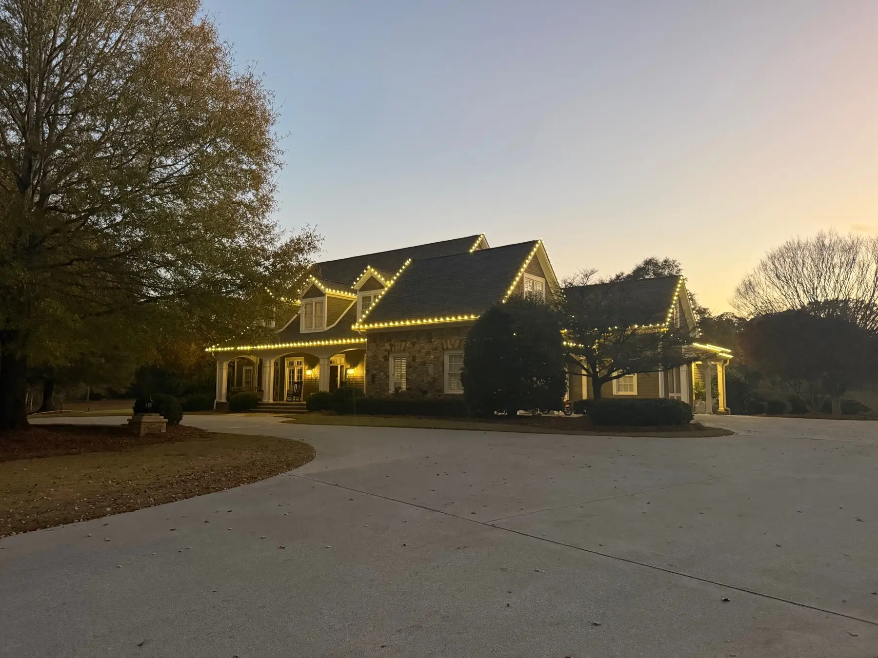 Craftsman home at sunset with warm white C9 bulbs running the full front roofline and evenly spaced along every gable and dormer